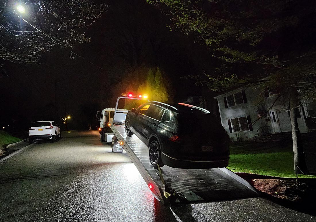 About Castle Towing Chappaqua New York Flatbed tow truck towing car at night