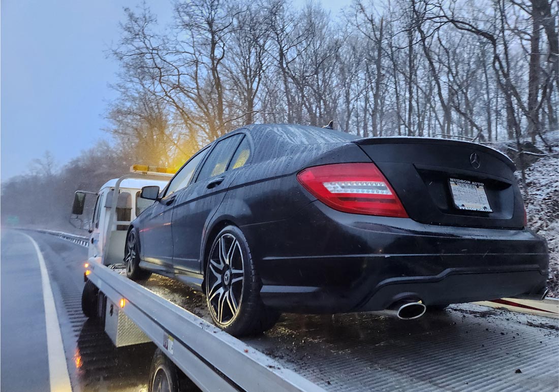 About Castle Towing Chappaqua New York Flatbed tow truck towing car in rain